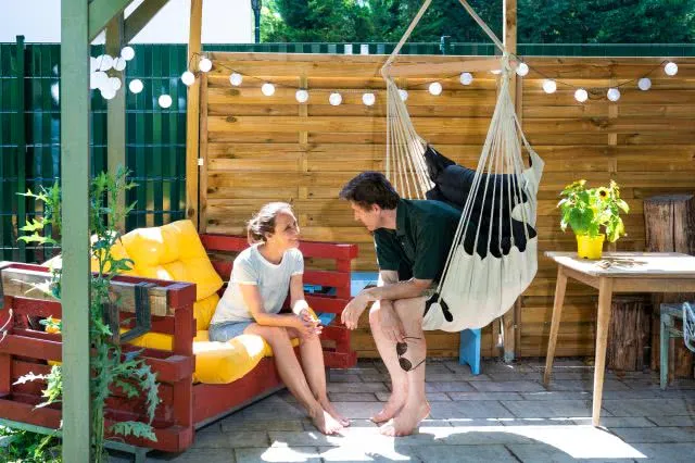 H&auml;ngesessel auf Terrasse gef&uuml;ttert neben Couch